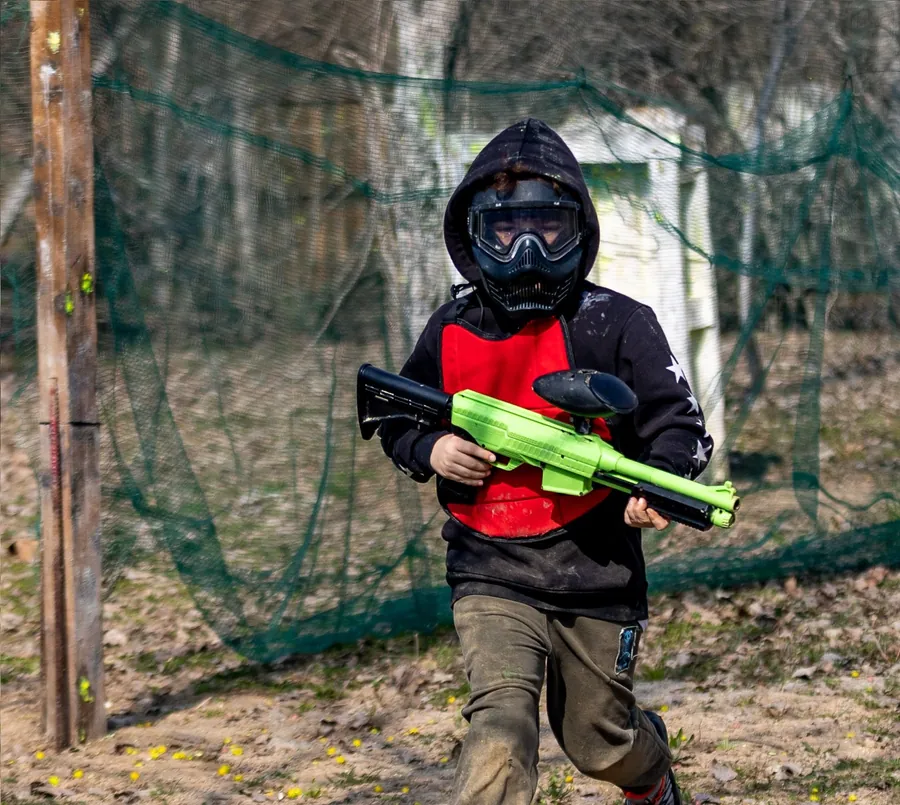 Giovane allievo della scuola paintball kids in azione